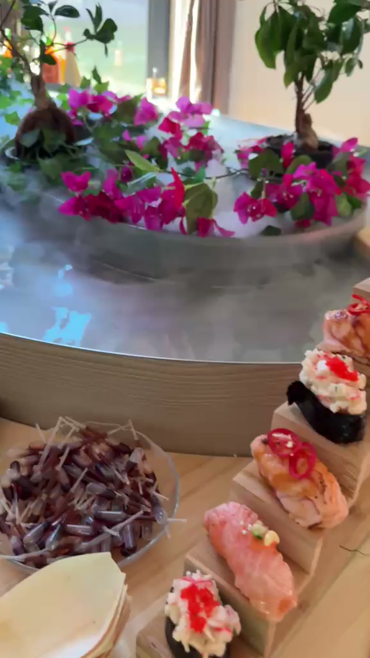 Bite-sized food on a wooden boat, mist rolling over the river
