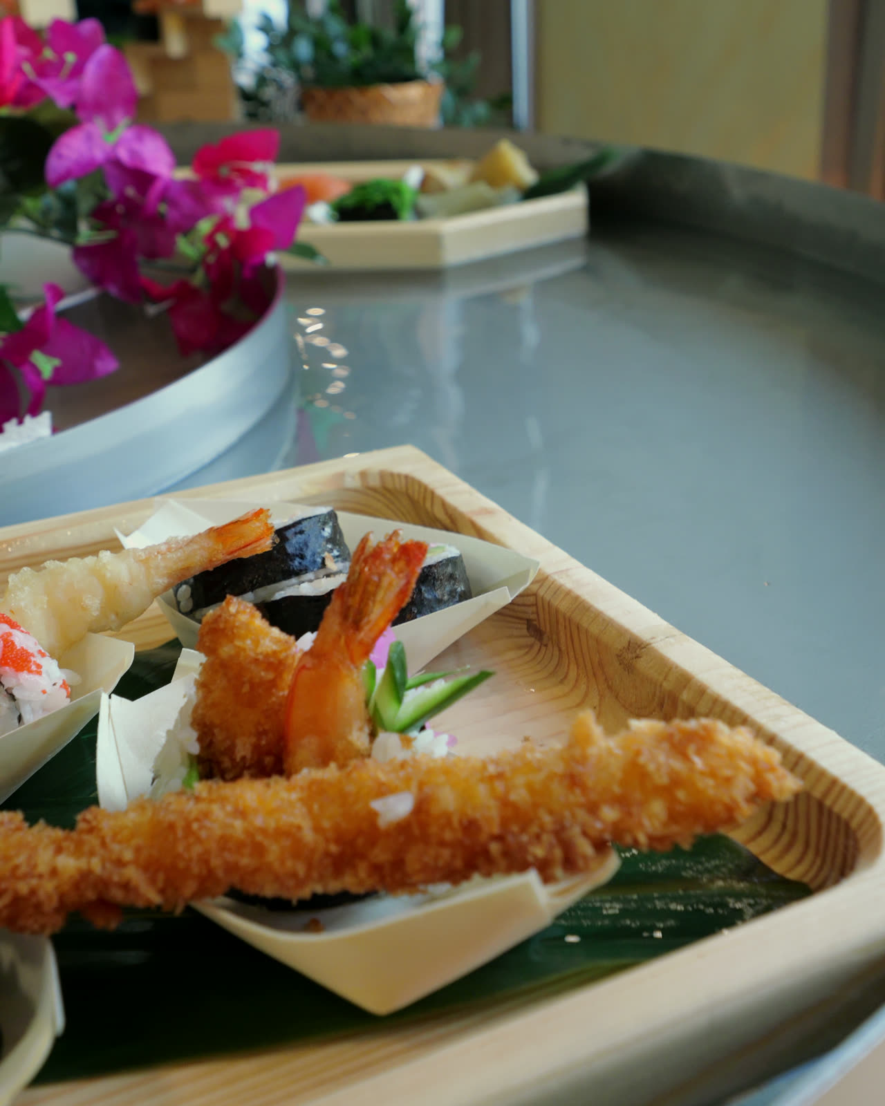 Tempura and maki up close on a wooden boat